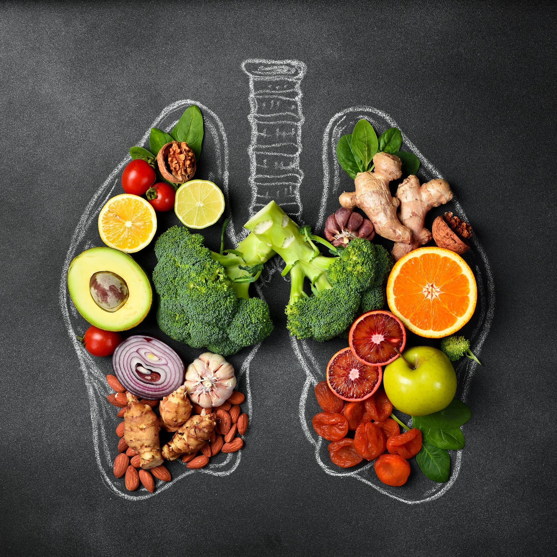 Lungs outline filled with healthy foods like broccoli, avocado, citrus fruits, and nuts on a dark background.