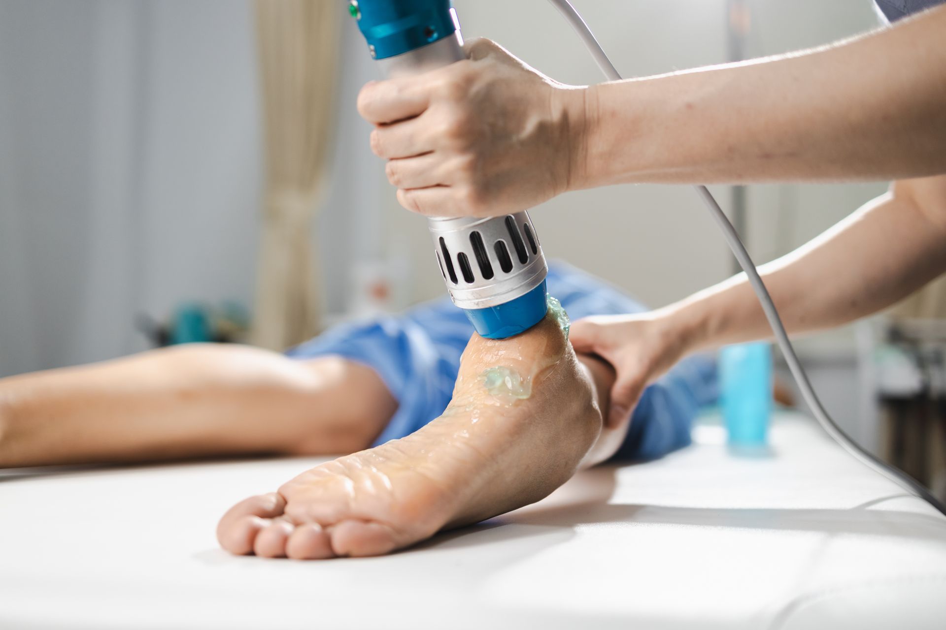 Person receiving shockwave therapy on their ankle.