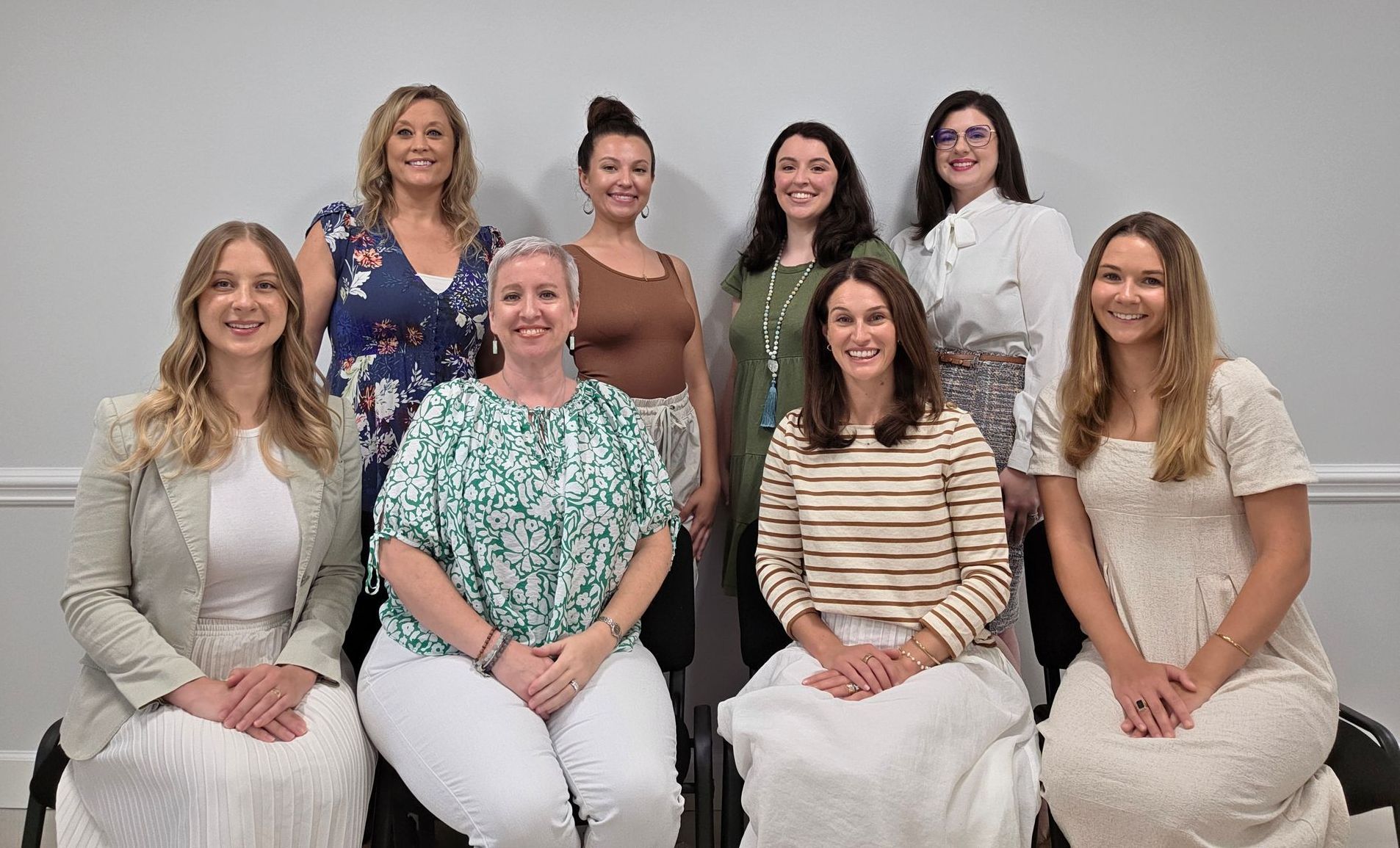 A group of women are posing for a picture together in a room.