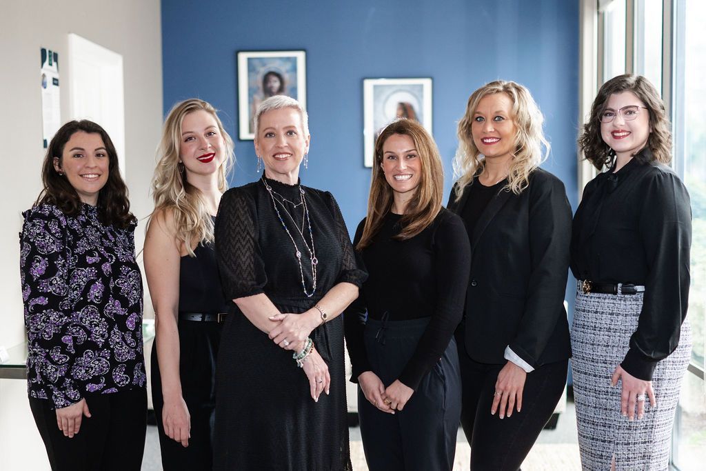 A group of women are posing for a picture together in a room.