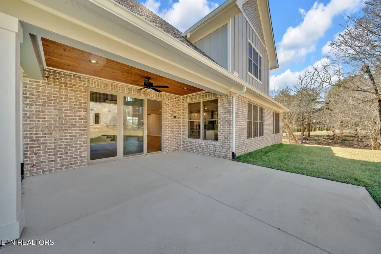 Back porch with brick walls, concrete floor, and light blue siding.
