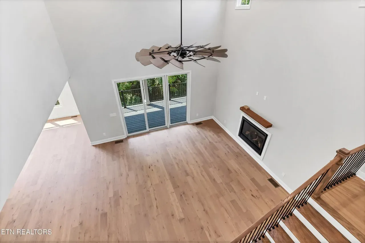 High-angle view of a living room with wooden floors, fireplace, and sliding glass doors.