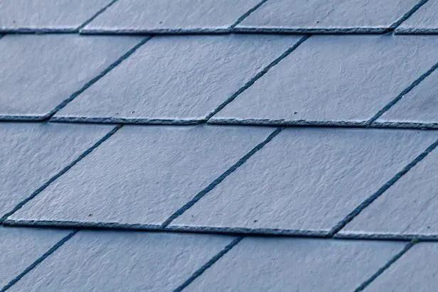 Close-up of diamond-shaped, blue-gray slate roof tiles.