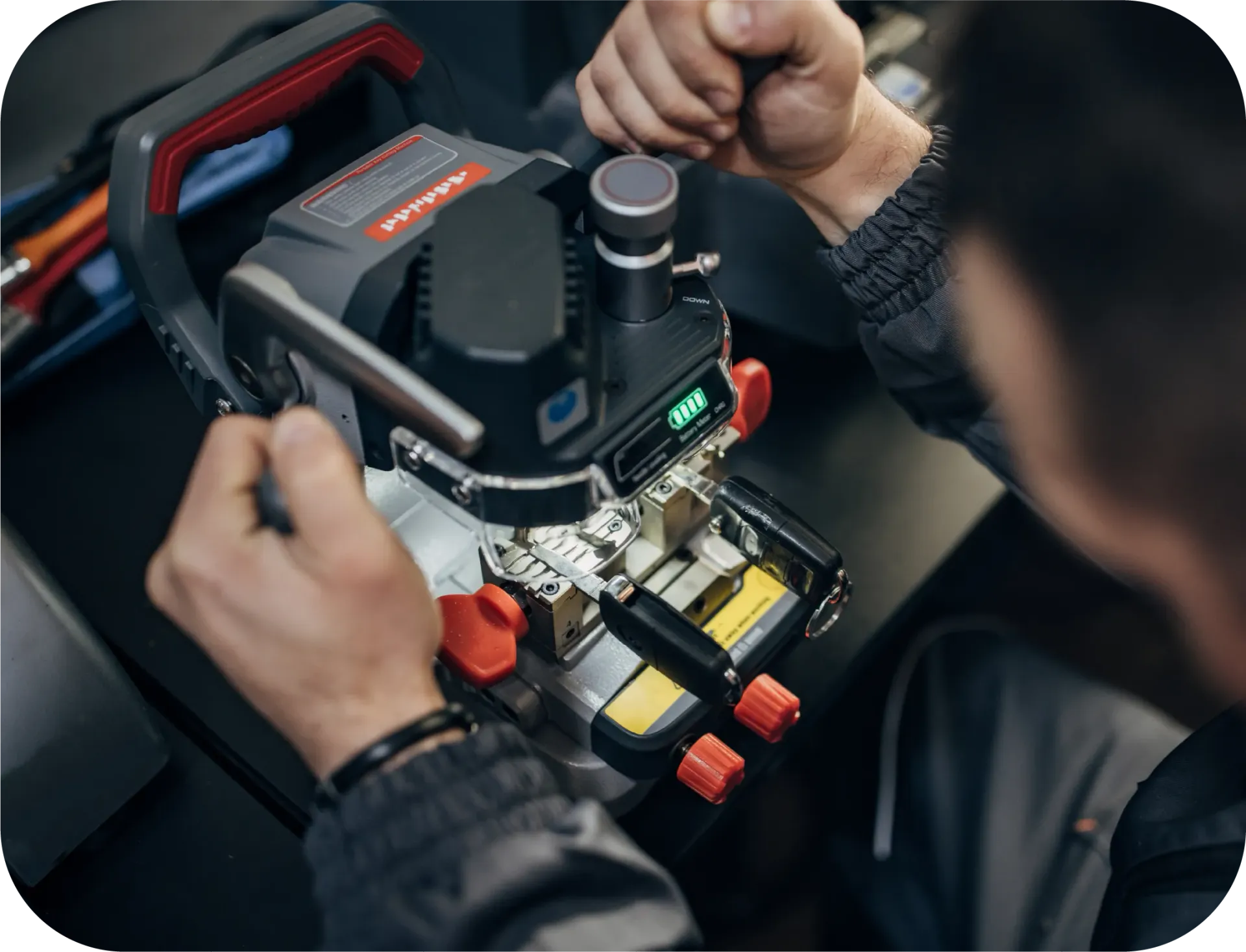 Hands of an electrician wiring a light switch, with visible colored wires and a wall outlet box.