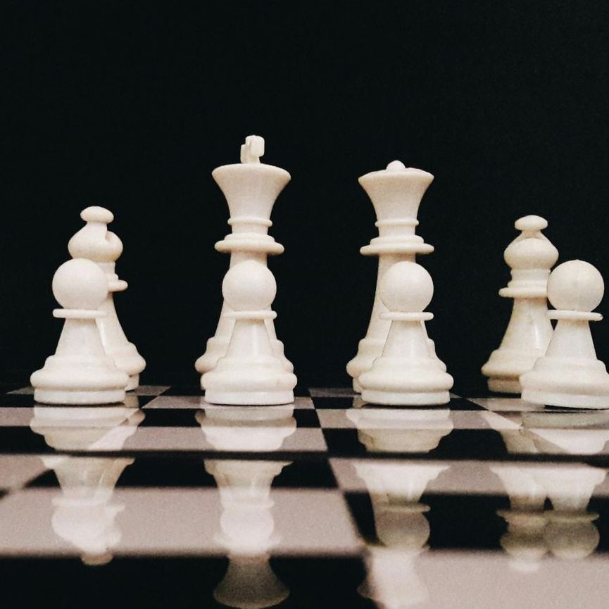 Piezas de ajedrez blancas sobre un tablero blanco y negro.