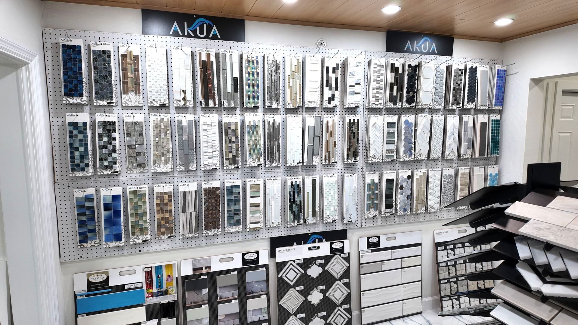 Tile samples displayed on a store wall. Various colors and textures visible.