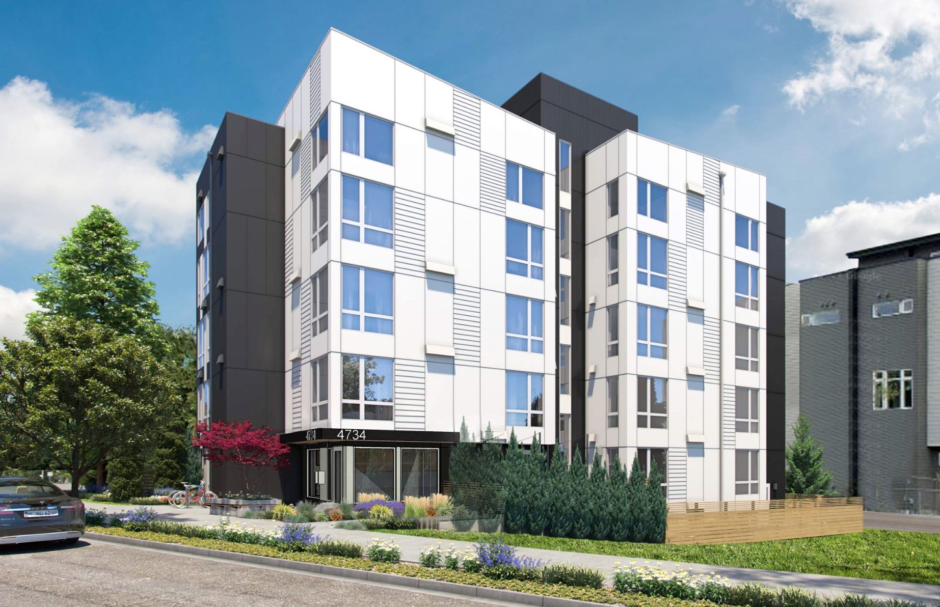 Modern white and black apartment building with large windows.