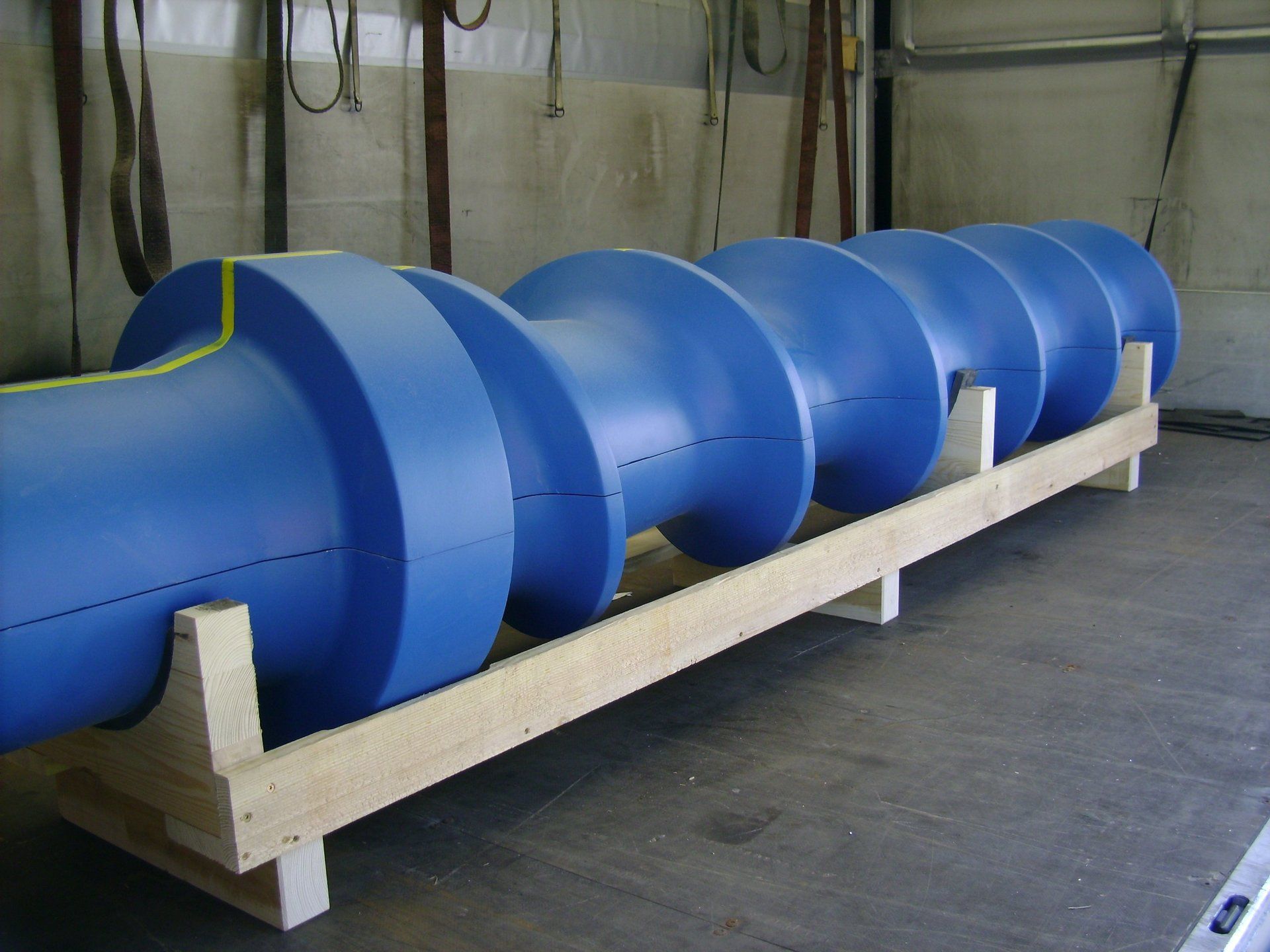 Eine Reihe von blauen Zylindern stehen auf einem Holzregal