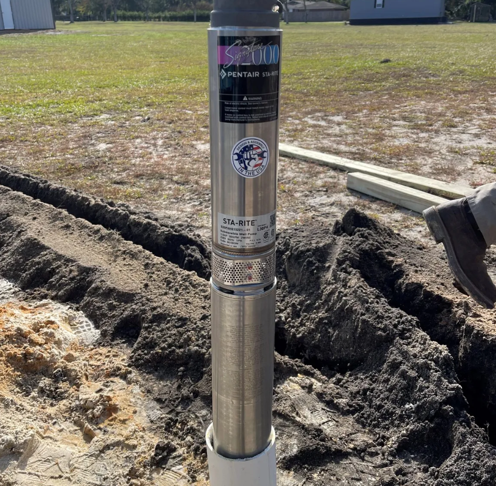 A water tank is sitting in front of a house under construction.