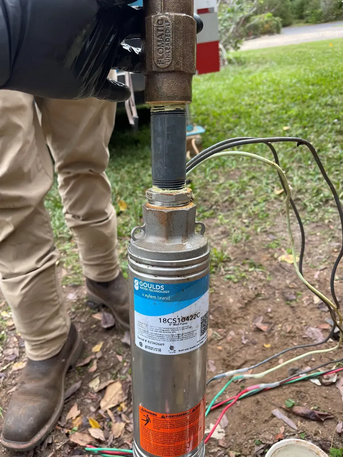 A person is standing next to a water pump.