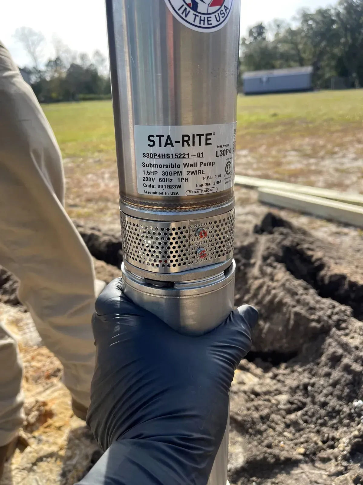 A person is holding a stainless steel water pump in their hand.