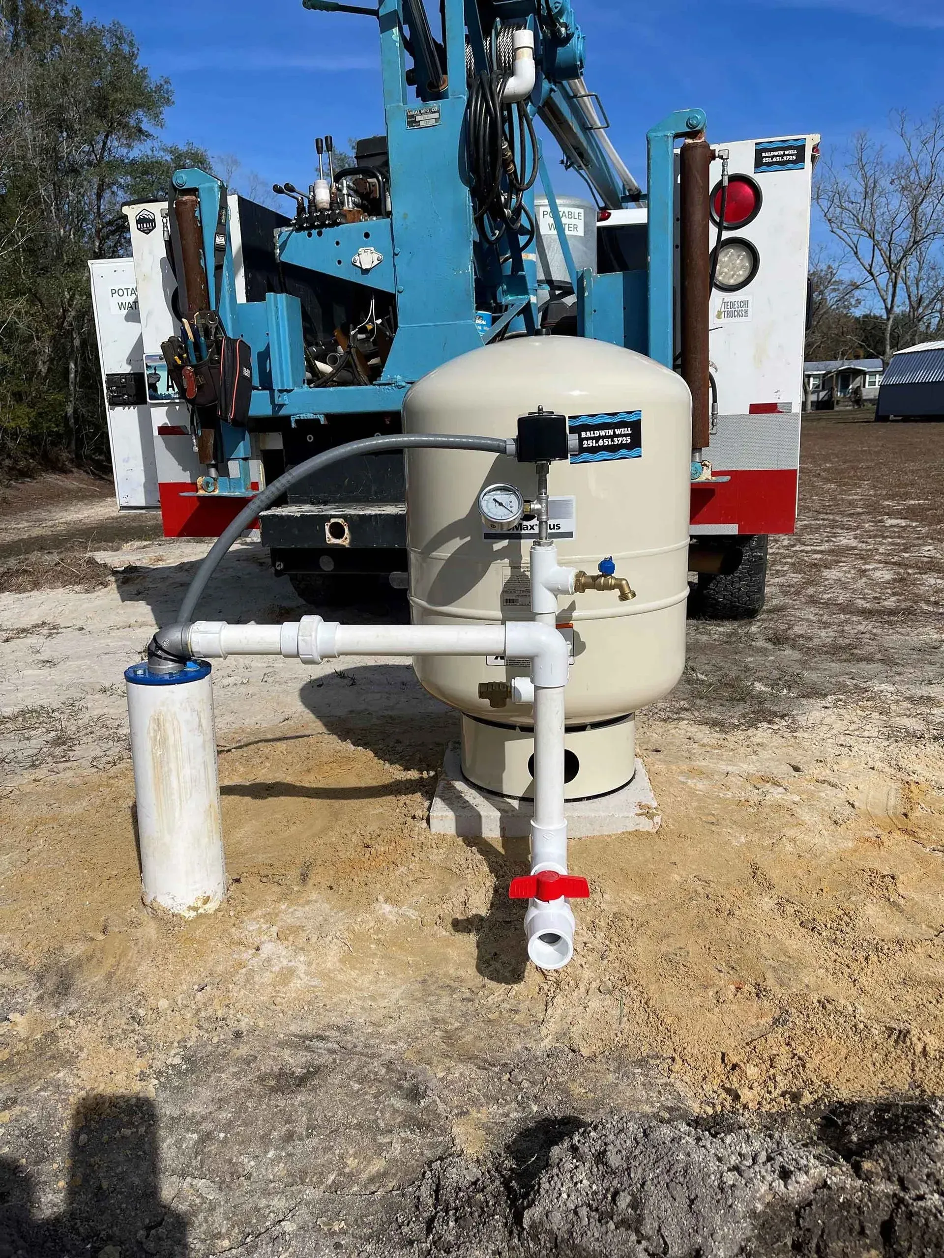 A water pump is sitting in the dirt next to a truck.