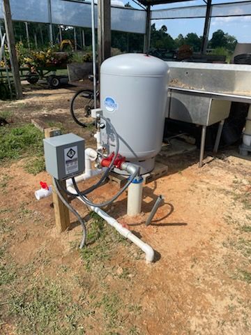 A person is cleaning a water filter next to a water tank.