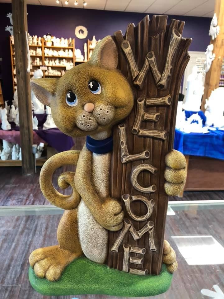 Person in green jacket working on a red semi-truck in a garage.