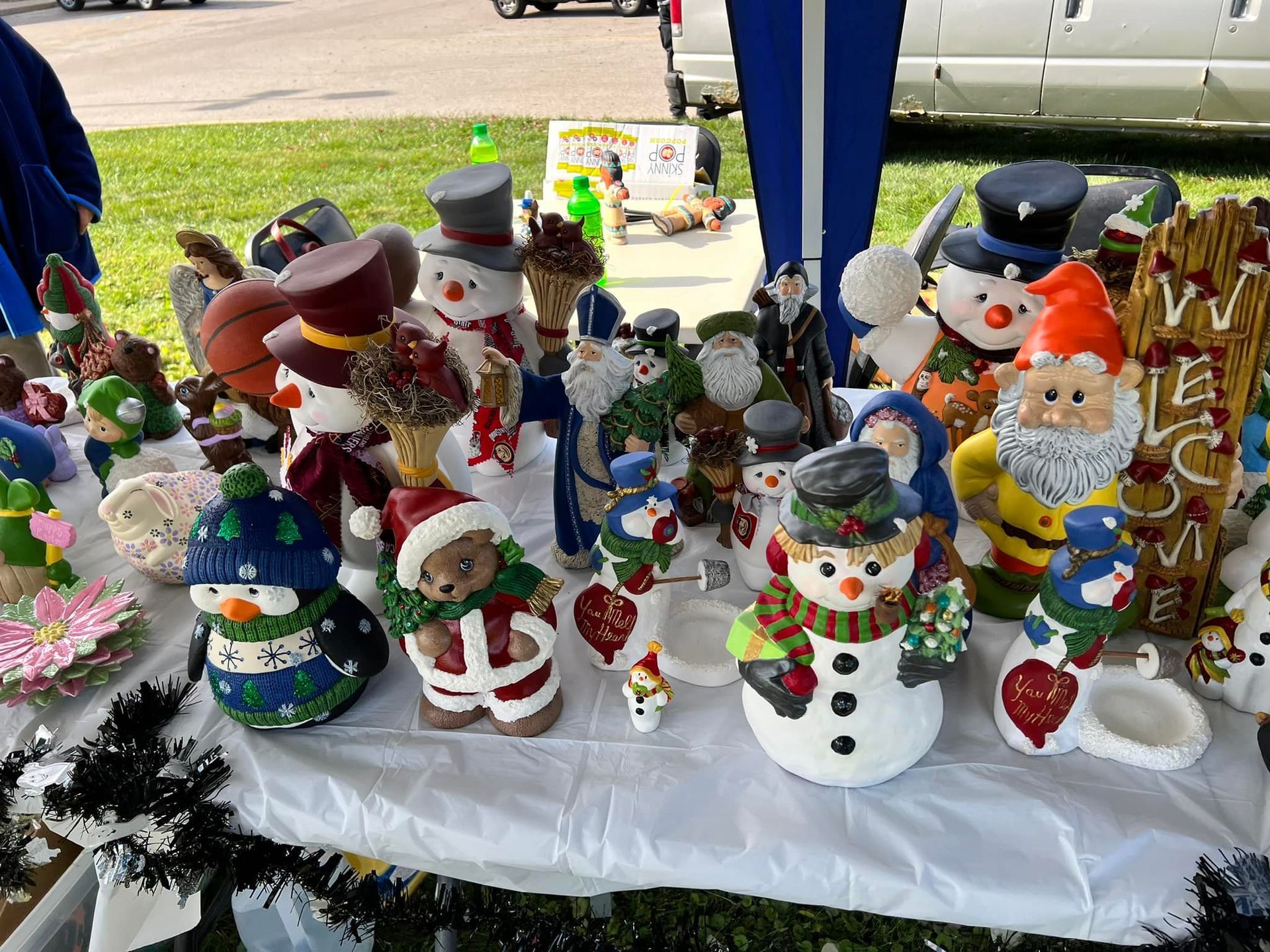 Table of ceramic holiday decorations, including snowmen, Santa, gnomes, and ornaments.