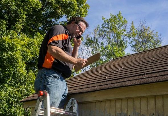 man inspecting roof