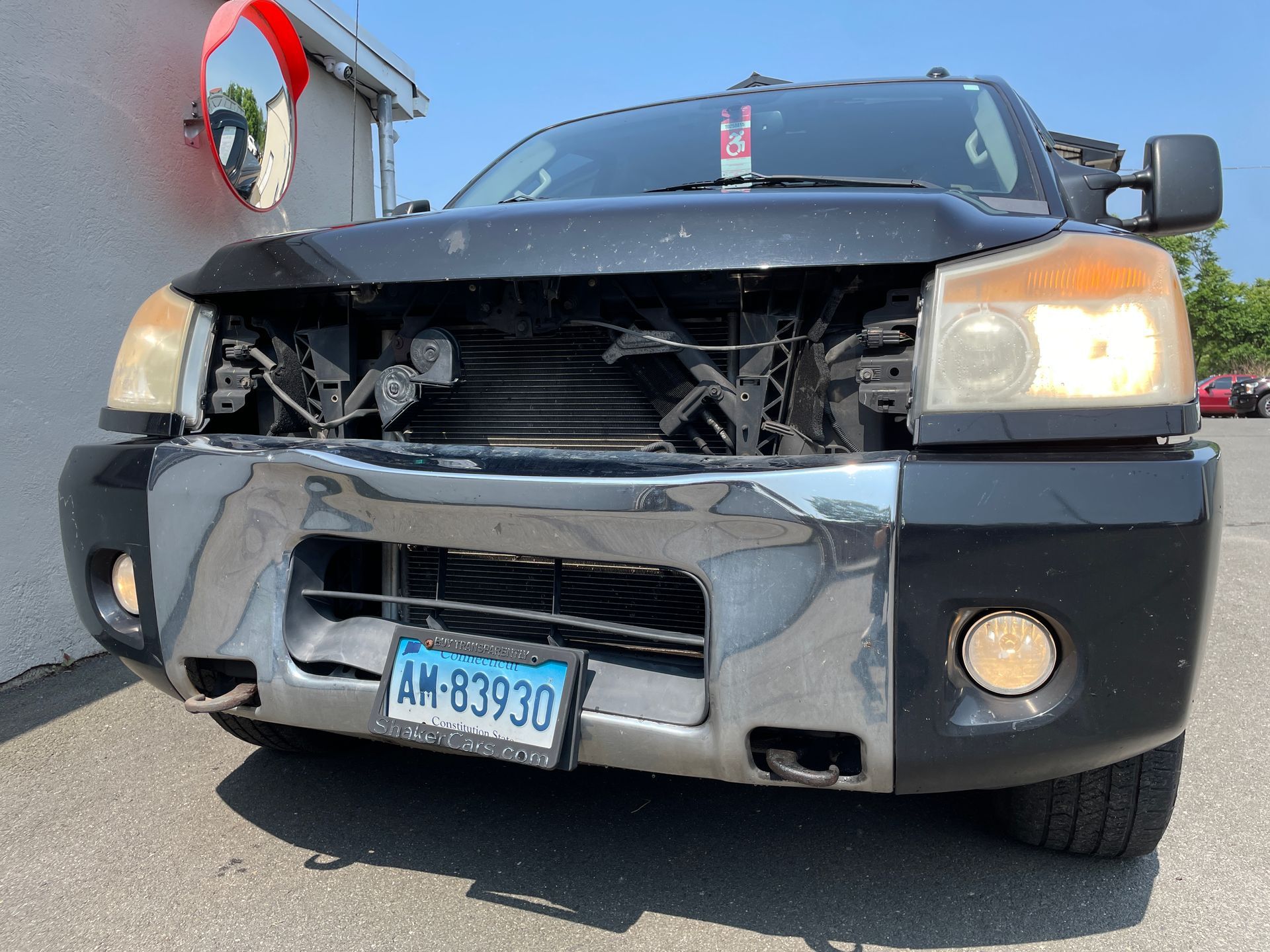 A black truck with front bumper damage.