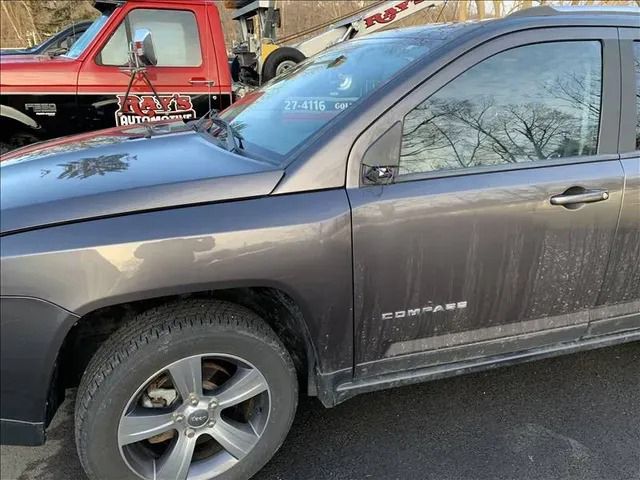 A jeep is parked in a parking lot next to a tow truck.