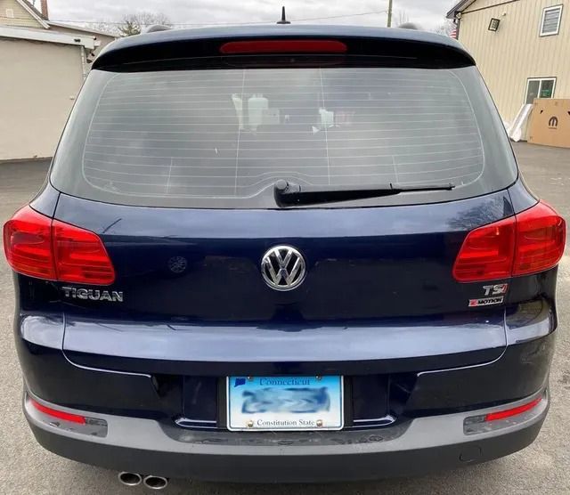 A blue volkswagen tiguan is parked in a parking lot