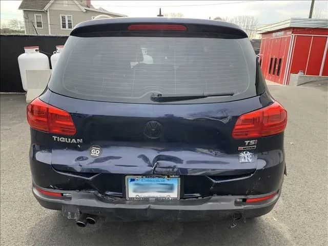 A blue volkswagen tiguan is parked in a parking lot