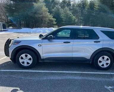 A silver ford explorer is parked in a parking lot.