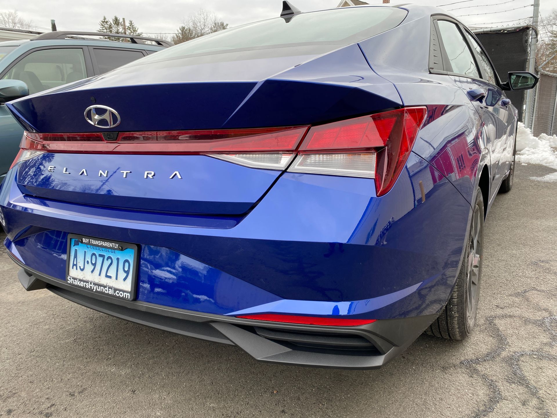 A blue hyundai elantra is parked on the side of the road.