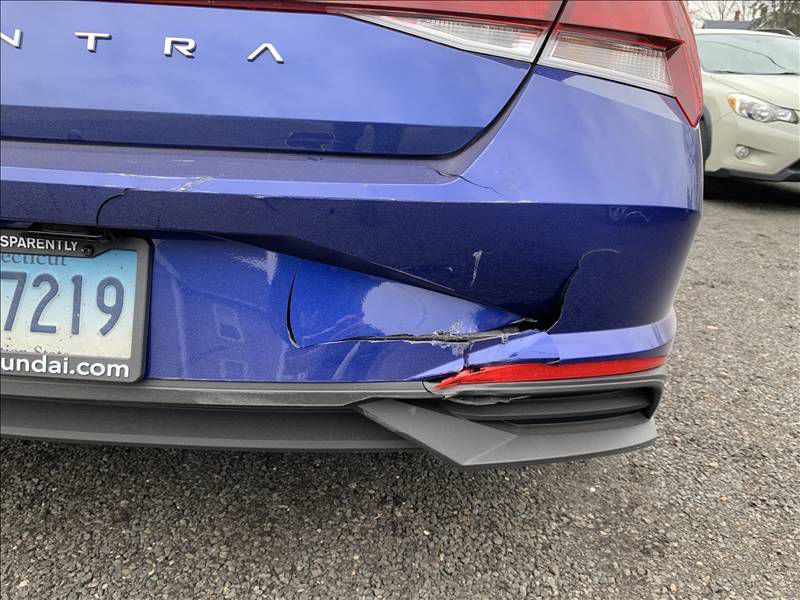 A blue car is parked in a parking lot.