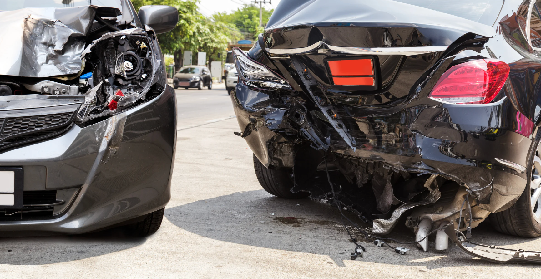 Two cars are damaged in a car accident on the side of the road.