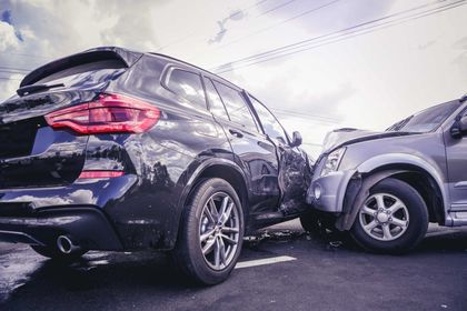 Two cars are involved in a car accident on the road.
