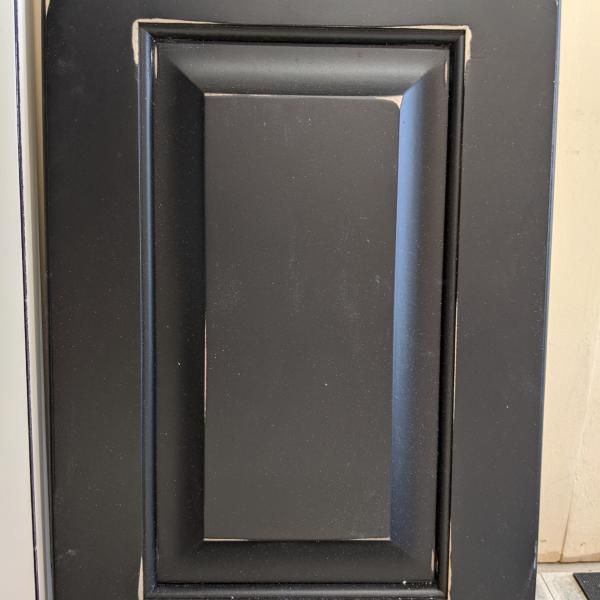 Black wall-mounted switch or blank panel with a dark rectangular center and beveled frame