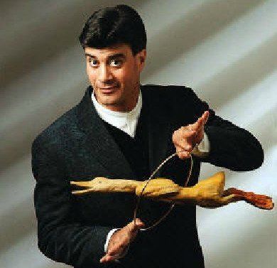 A man in a suit is holding a rubber duck and a ring.