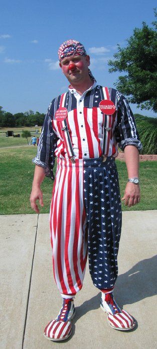A man in an american flag outfit is standing on a sidewalk