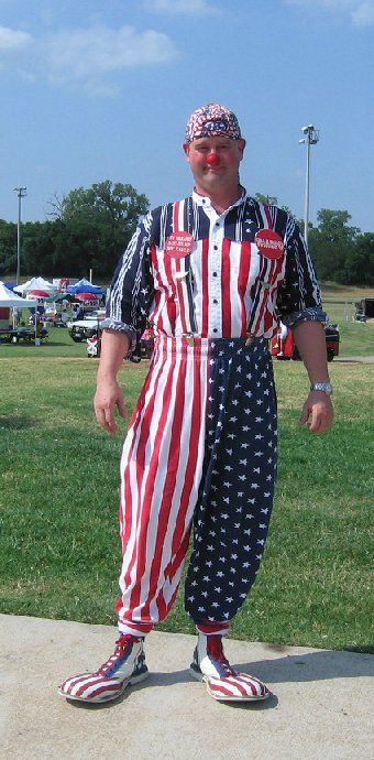 A man in an american flag jumpsuit is standing on a sidewalk
