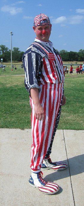 A clown wearing a red white and blue striped outfit