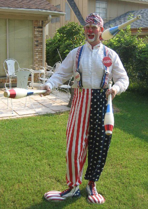 A man dressed as a clown holding a juggling stick
