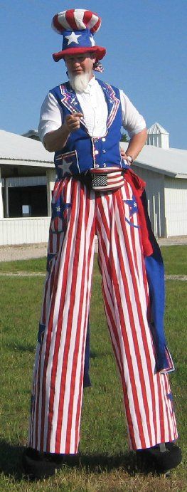 A man dressed as uncle sam is standing on stilts