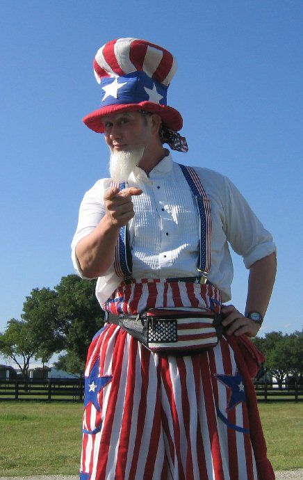 A man dressed as uncle sam is pointing at the camera