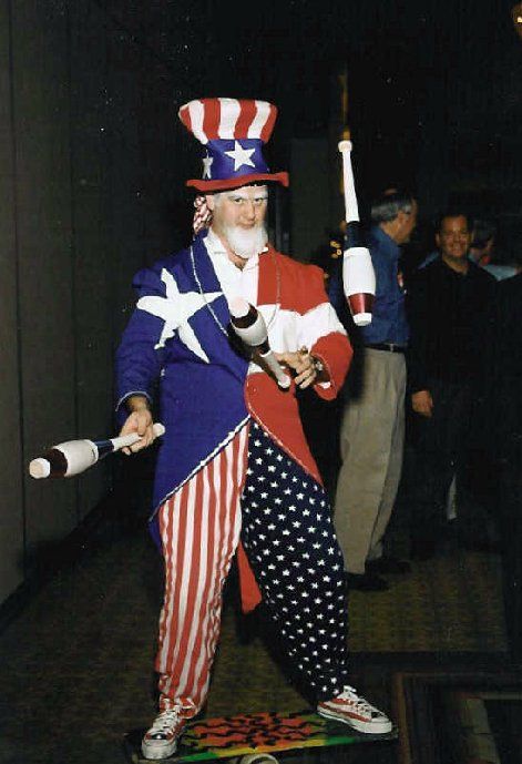 A man dressed as uncle sam is juggling clubs