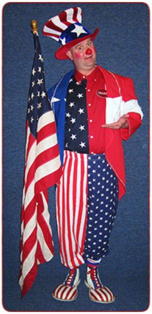 A clown in an uncle sam costume holds an american flag