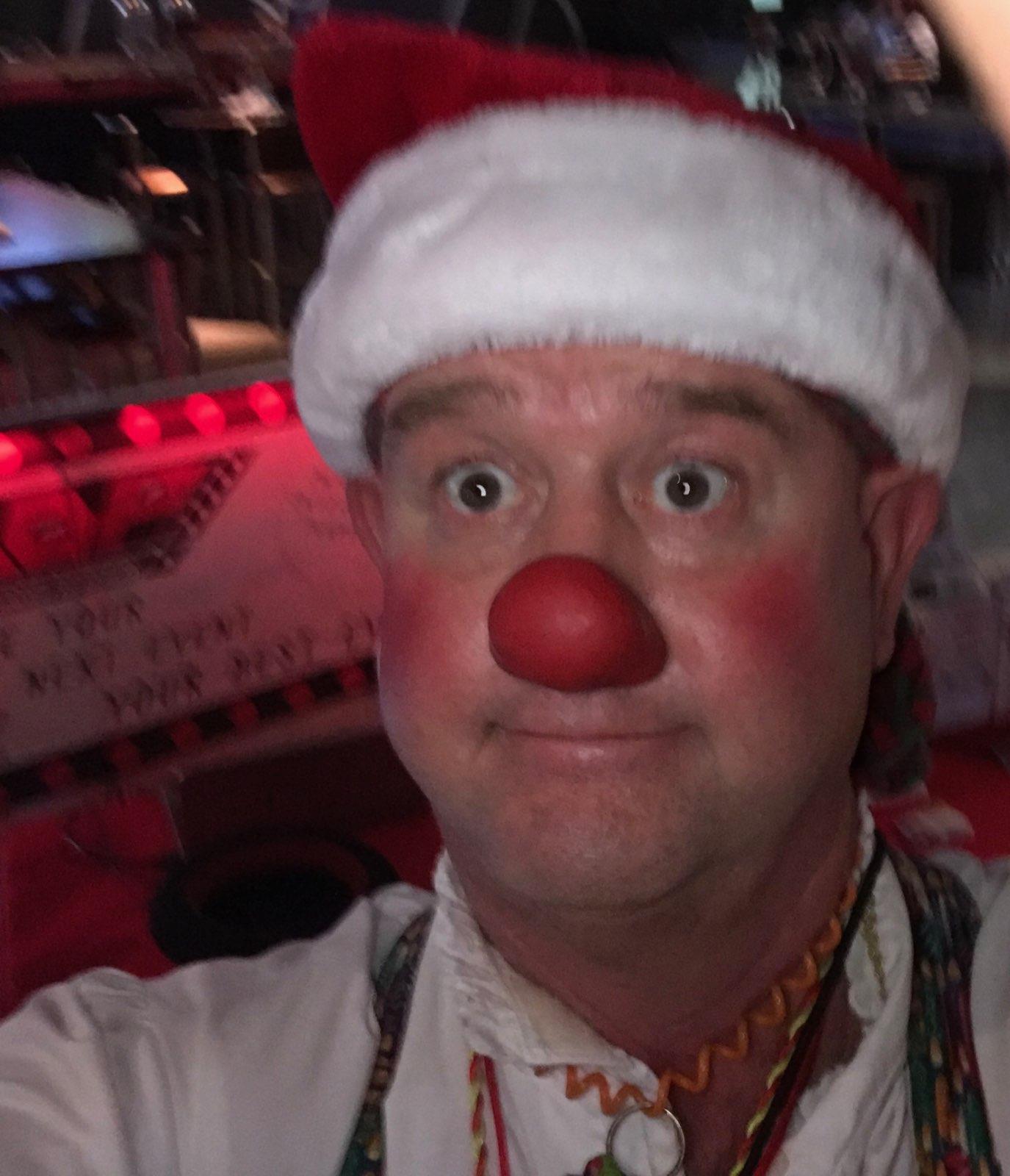 A man wearing a santa hat and a red nose