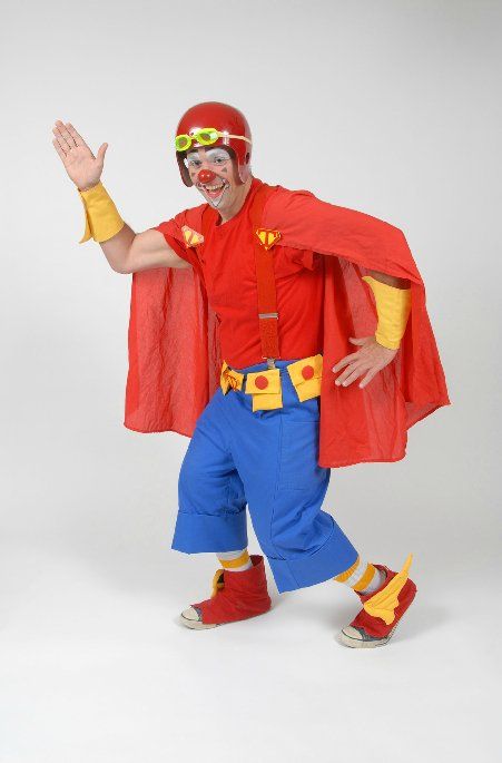 A clown dressed as a superhero with a red cape