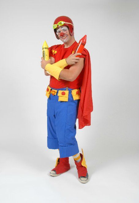 A clown in a red cape is holding a crayon