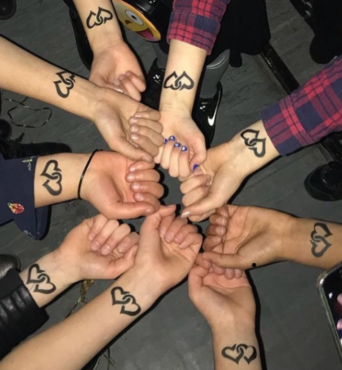 A group of people with hearts on their wrists