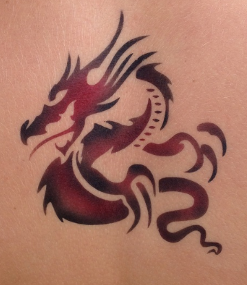A red and black dragon tattoo on a person 's back