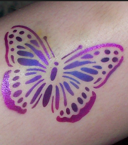 A person has a purple butterfly tattoo on their arm