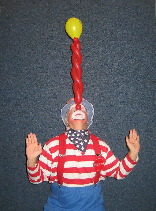 A clown with a balloon on top of his head