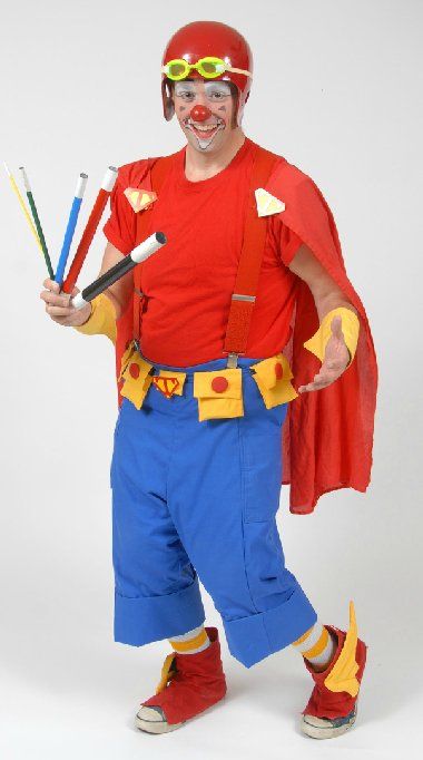 A clown in a red shirt and blue pants is holding pencils