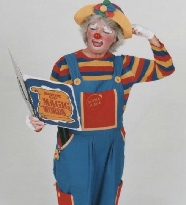 A clown is reading a book called magic words
