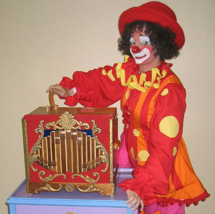 A woman dressed as a clown is holding a box