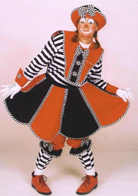 A woman in a clown costume is standing with her arms outstretched